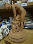 A terracotta model of a nude bather on a circular stand