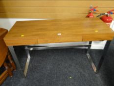 A neat modern light wood & chrome legged console table with centre drawer