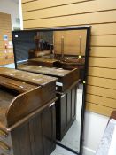 A large black wooden framed wall mirror