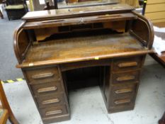 An English-made oak roll top desk with two banks of four drawers & pigeon hole interior (key with