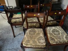 A set of eight Regency-style rattan seated dining chairs fitted with loose cushions