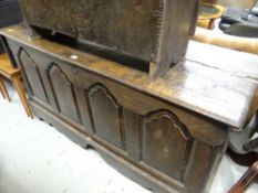 An early nineteenth century four panel oak blanket chest with shaped apron base