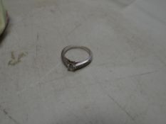 An 18k white gold diamond solitaire ring with diamond shoulders