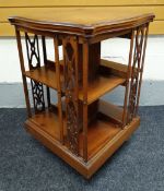 AN EDWARDIAN MAHOGANY ROTARY BOOKCASE having a shaped top and openwork bookends, 53cms squared