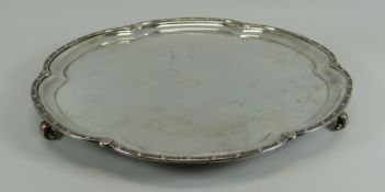 A SILVER SALVER of lobed form on three scroll supports and having an Oriental-style rim, Sheffield