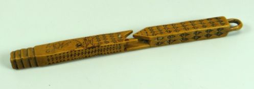 AN EARLY NINETEENTH CENTURY FRUITWOOD CARVED TREEN KNITTING STICK with primitive chiselling and