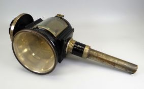 AN ANTIQUE CARRIAGE LAMP in black painted metal and with large glass convex glass, patent mark and