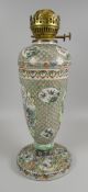 A FAMILLE VERT PORCELAIN OIL-LAMP on a spreading circular foot and of baluster form bearing a