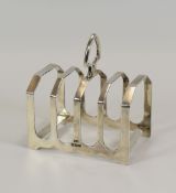 A SILVER FOUR-SECTION TOAST RACK on a shaped base with spear shaped ring handle, Sheffield 1936, 3.