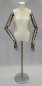 A MID-TWENTIETH CENTURY TAILOR'S FEMALE DUMMY on a painted wooden circular base and having wooden