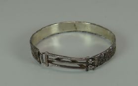 A SILVER BANGLE in the form of a dry-stone wall with `farm-gate` clasp, 26.8gms