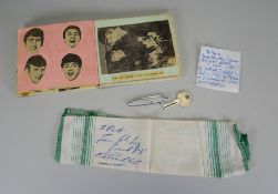 A SMALL AUTOGRAPH BOOK CONTAINING THE BEATLES SIGNATURES with numerous stuck down newspaper cuttings