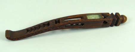 A NINETEENTH CENTURY CURVED TREEN KNITTING SHEATH with geometric carving and inscription behind