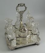 A GEORGIAN SILVER EIGHT BOTTLE CRUET SET on four claw corner supports and with decorative mask
