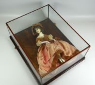 AN UNUSUAL ANTIQUE DOLL within a glass display case and in elaborate dress and bonnet with legs