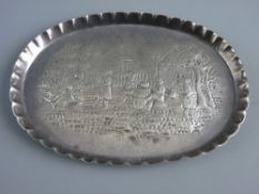 AN OVAL SILVER DISH with shallow crimped border and having a scene of figures in a garden at play