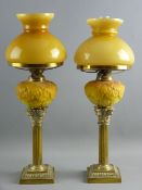 A PAIR OF SQUARE BASED BRASS SHORT STEMMED CORINTHIAN COLUMN OIL LAMPS with milk glass yellow leaf