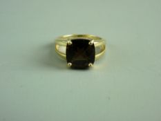 A NINE CARAT GOLD SMOKEY QUARTZ DRESS RING having a split shank and a square cut quartz, 5 grms