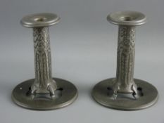 A PAIR OF LIBERTY & CO TUDRIC PEWTER CANDLESTICKS designed by Archibald Knox with detachable drip