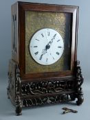 A CHINESE TWIN FUSEE TABLE CLOCK ON STAND, the 17 cms diameter white enamel dial set with Roman