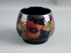 A SMALL MOORCROFT 'POMEGRANATE' SHALLOW FOOTED BOWL decorated on a cobalt ground, impressed '