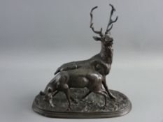 A BRONZED SPELTER STAG & DOE GROUP, modelled in animated pose on a naturalistic oval base,