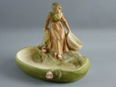 A ROYAL DUX PORCELAIN FIGURAL BOWL of a young girl on a rocky crop holding an open basket, the