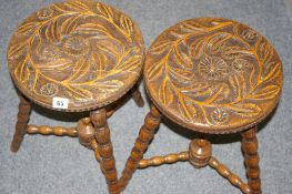A CIRCULAR PAIR OF FLORAL CARVED STOOLS on bobbin turned supports and urn conjoined cross