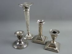 TWO SHORT STEMMED SQUARE BASED SILVER CANDLEHOLDERS, a circular based short stemmed silver