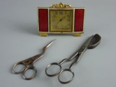 A SMALL GILT METAL FRAMED SQUARE DIAL TRAVEL CLOCK with side oblong red enamel panels, in its