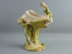 A ROYAL DUX PORCELAIN TABLE CENTREPIECE formed as an open shell upon a bed of lilies and two young