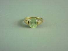 A NINE CARAT GOLD OVAL PERIDOT DRESS RING, 3 grms gross, size 'N'