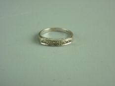 AN EIGHTEEN CARAT WHITE GOLD HALF HOOP ETERNITY RING of eight tiny diamonds, 3.8 grms gross