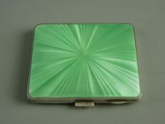 AN ENGINE TURNED LADY'S SILVER CIGARETTE CASE with a green enamel lid, 3 troy ozs, Birmingham 1940