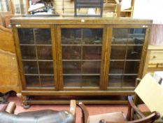 Good size polished bookcase with three glazed doors on bun feet