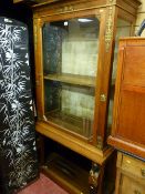 A continental empire-style display cabinet on an open stand with gilt & ebonized figural corbels