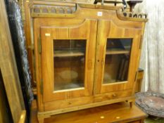 A continental walnut two-door display cabinet with lower drawers