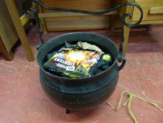 A metal swing-handle cauldron full of coal