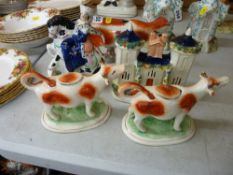 A pair of Staffordshire cow creamers, a Staffordshire cow creamer with milkmaid (damaged), a