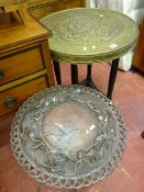 An Oriental brass topped table on ebony supports with bun feet and a carved folding table