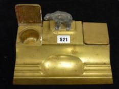 A brass desk set with bear decoration