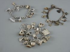THREE SILVER CHARM BRACELETS with approximately twenty four, nine and eleven charms attached