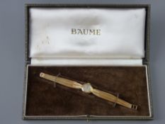 A LADY'S NINE CARAT GOLD CIRCULAR DIAL BAUME WRISTWATCH with shaped incorporated bracelet, total