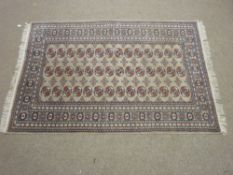 AN EARLY 20th CENTURY GREY GROUND TURKOMAN RUG having a wide nine row border and the centre having a