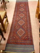 A MESHWANI RUNNER, red ground with repeating central diamond pattern and plain bordered ends, 274