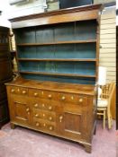 AN EARLY TO MID 19th CENTURY OAK NORTH WALES DRESSER having a three shelf rack over a base having