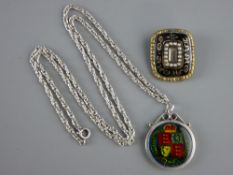 AN EARLY VICTORIAN MOURNING BROOCH and an enamelled 1887 shilling in a pendant mount with sterling
