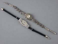 A LADY'S SILVER ENCASED OVAL DIAL COCKTAIL WATCH, the plain face surrounded by tiny diamonds with