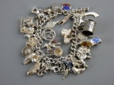 A SILVER CHARM BRACELET WITH THIRTY EIGHT CHARMS ATTACHED, some enamelled, 2.8 troy ozs gross