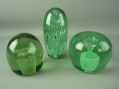 THREE VICTORIAN GREEN GLASS DUMP PAPERWEIGHTS, two having floral plantpot inclusions, the other with